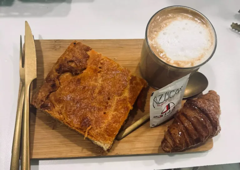 Desayuno compuesto por: ración de empanada, croissant y café