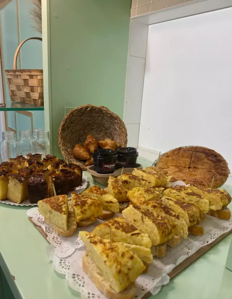 Pinchos de tortilla de patata, croissants, bizcocho, cafés.... sobre una mesa