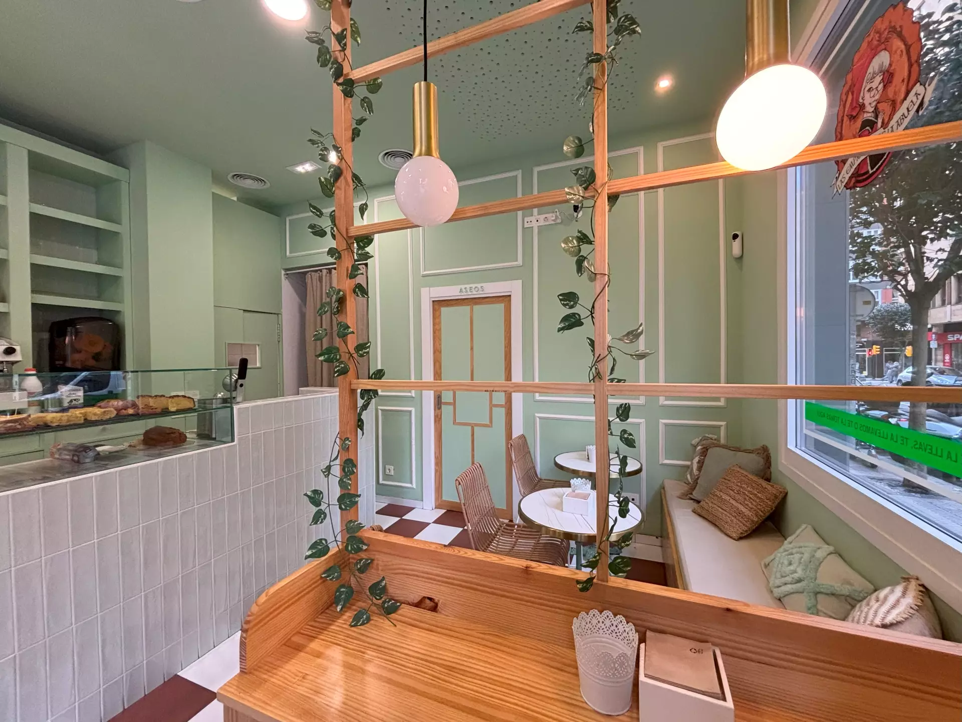 Vista de las mesas de la cafetería a través de una cristalera de madera