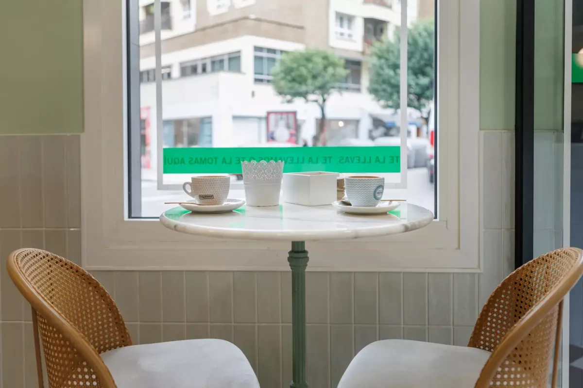 Mesa redonda junto a dos sillas y dos cafés
