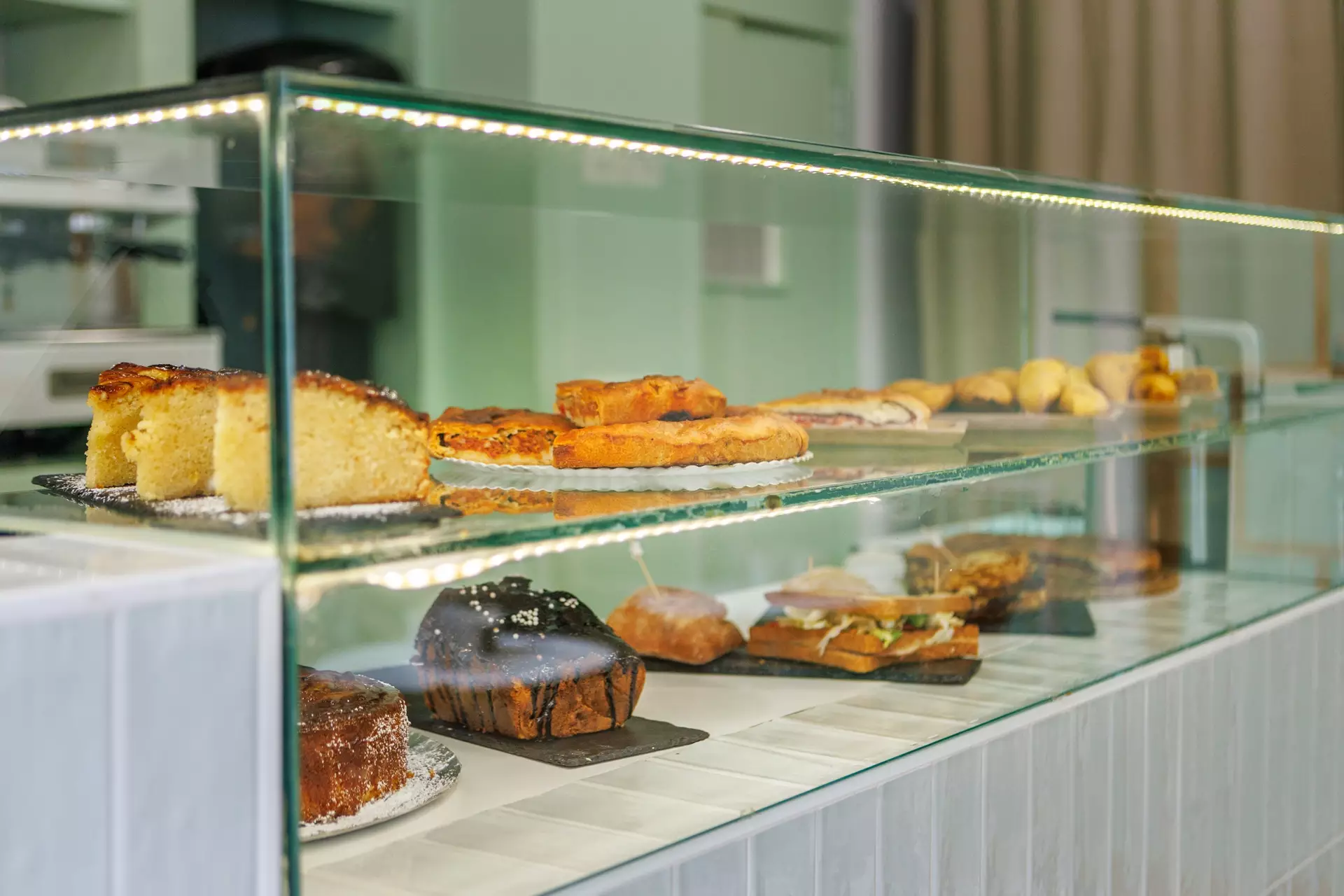 Expositor con productos de desayuno: bizcochos, sándwiches, empanadas...